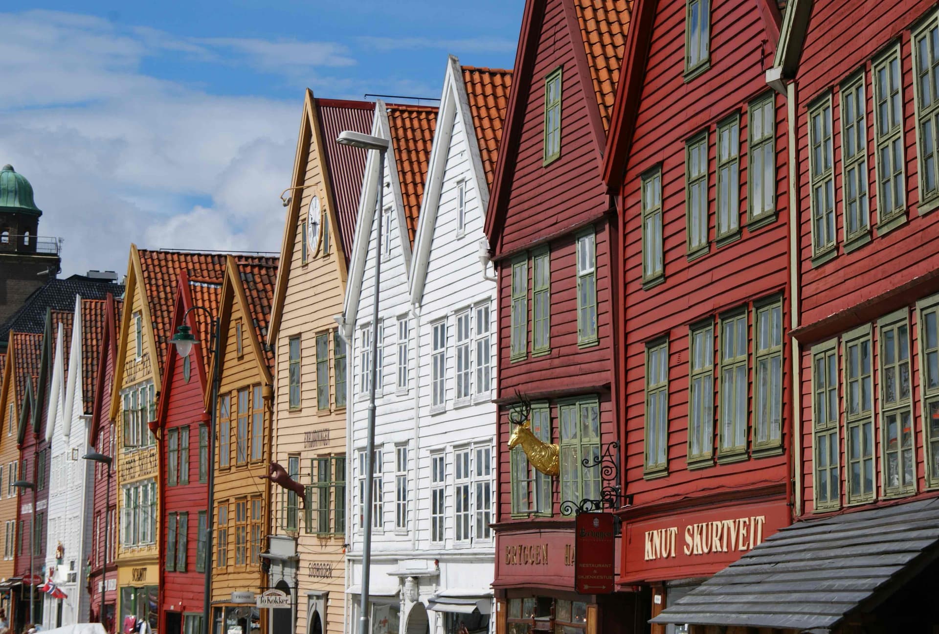 Bryggen Wharf in Bergen, colorful wooden Hanseatic buildings reflected in the water.